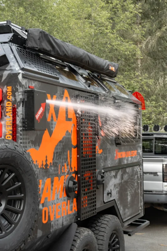 A Mammoth Overland XLE terepjáró lakókocsi háromnegyedes külső nézetből, narancssárga dekorációval