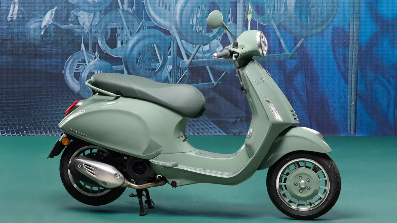 Zöld Vespa a 80. évforduló grafikus háttere előtt