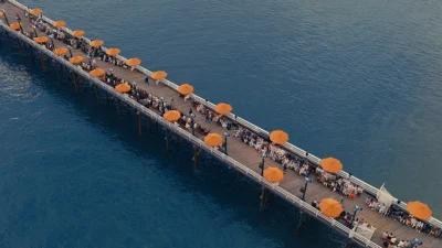 A Zegna Spring/Summer 2027 La Villeggiatura bemutató helyszíne, a Malibu Pier narancssárga napernyőkkel