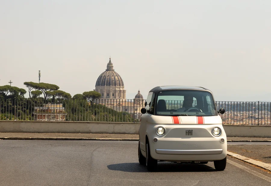 Fiat Topolino mopedautó Róma felett, a Szent Péter-bazilika kupolájával