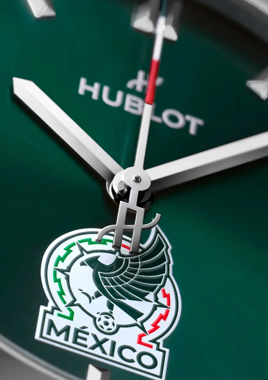 Makróközeli a Hublot zöld számlapjáról a HUBLOT felirattal és a mexikói címerrel