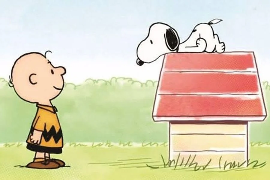 Snoopy és Charlie Brown a Peanuts klasszikus rajzán, a piros tetejű kutyaházzal