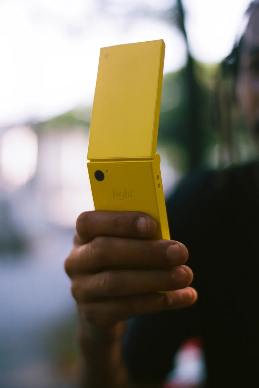 Sárga Light Phone Flip becsukva, kézben tartva