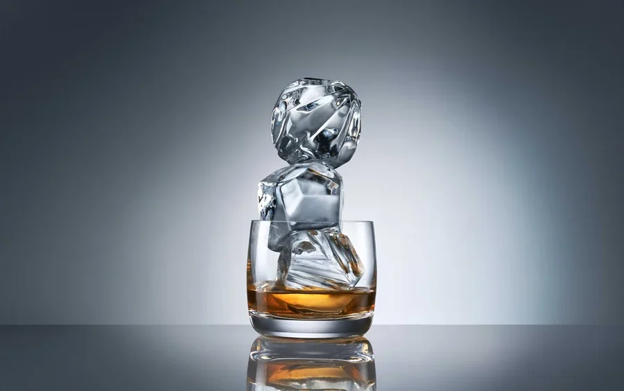 Gyémánt formájú jégdarabok egy pohár whiskyben