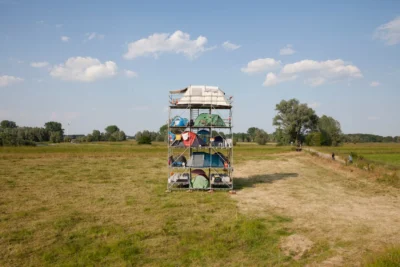 Többszintes fémállványzat sátrakkal egy füves mező közepén, tiszta égbolt alatt